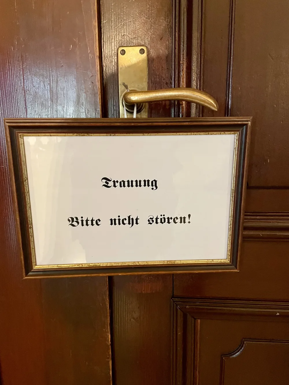 Schild an einer Tür im Standesamt mit der Aufschrift „Trauung, bitte nicht stören!“