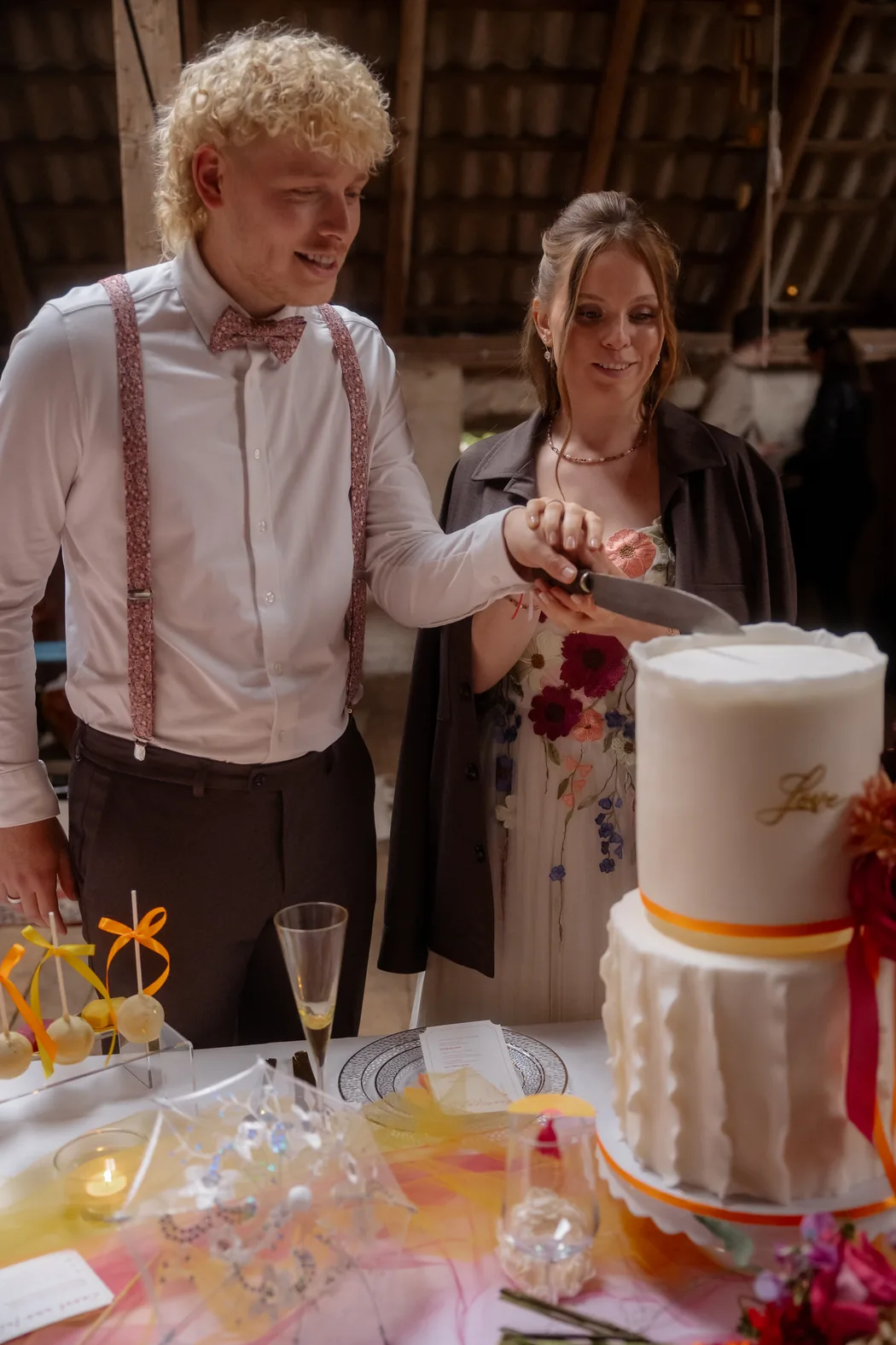Brautpaar schneidet gemeinsam die Hochzeitstorte an
