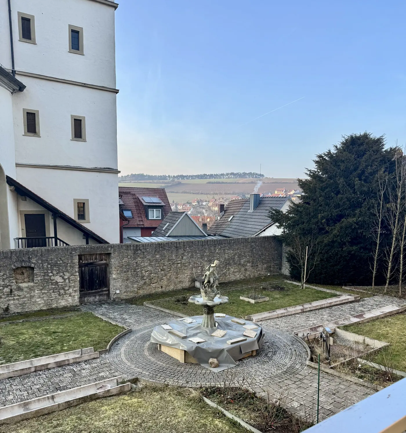 Blick vom Hof der Burg Arnstein über die alte Bruchsteinmauer auf die Hügel dahinter