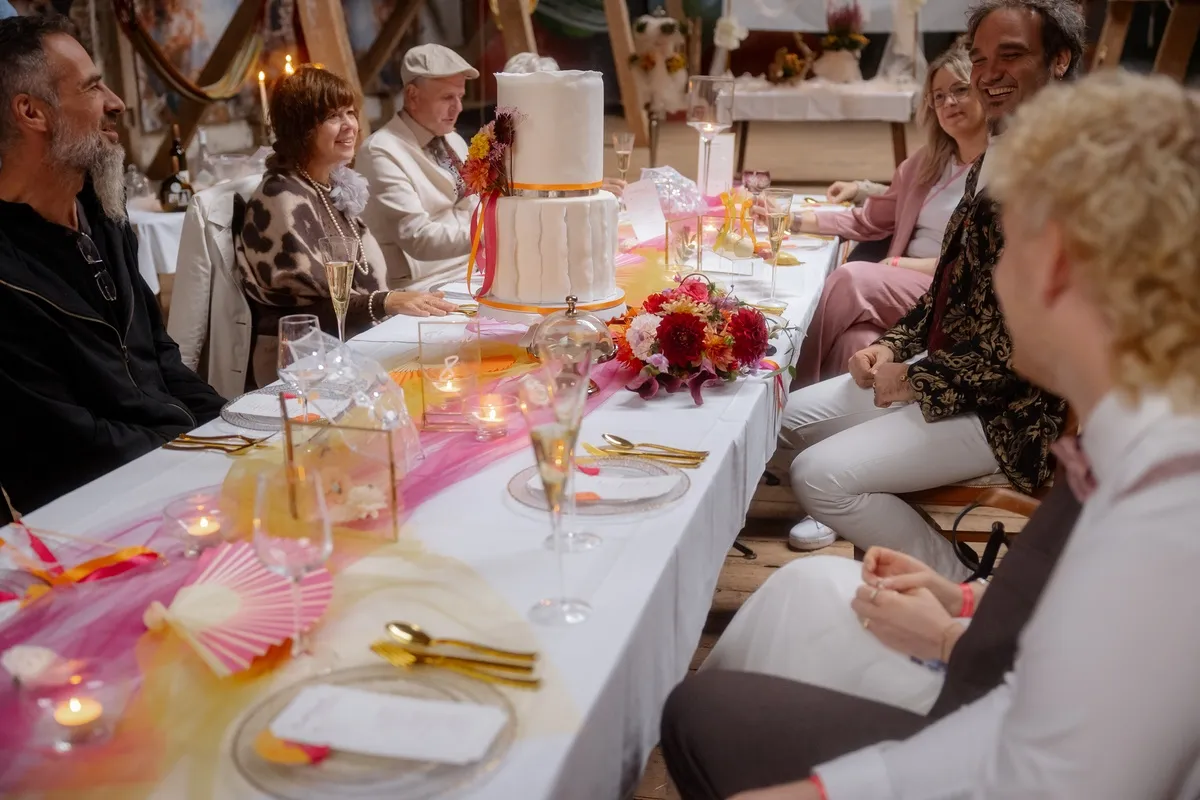 Gäste lachen zusammen an der gedeckten Tafel
