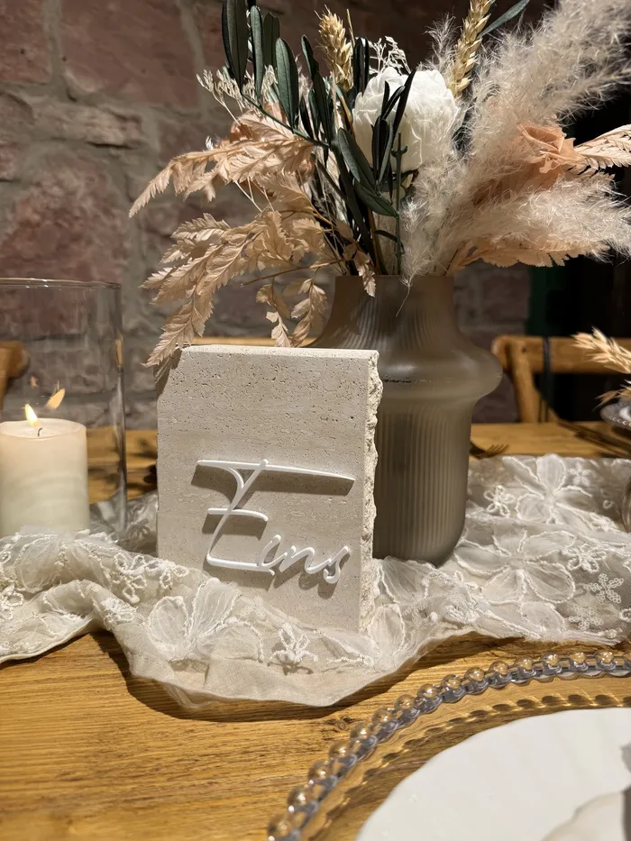 Tischnummer „Eins“ als Schriftzug auf einem Steinblock