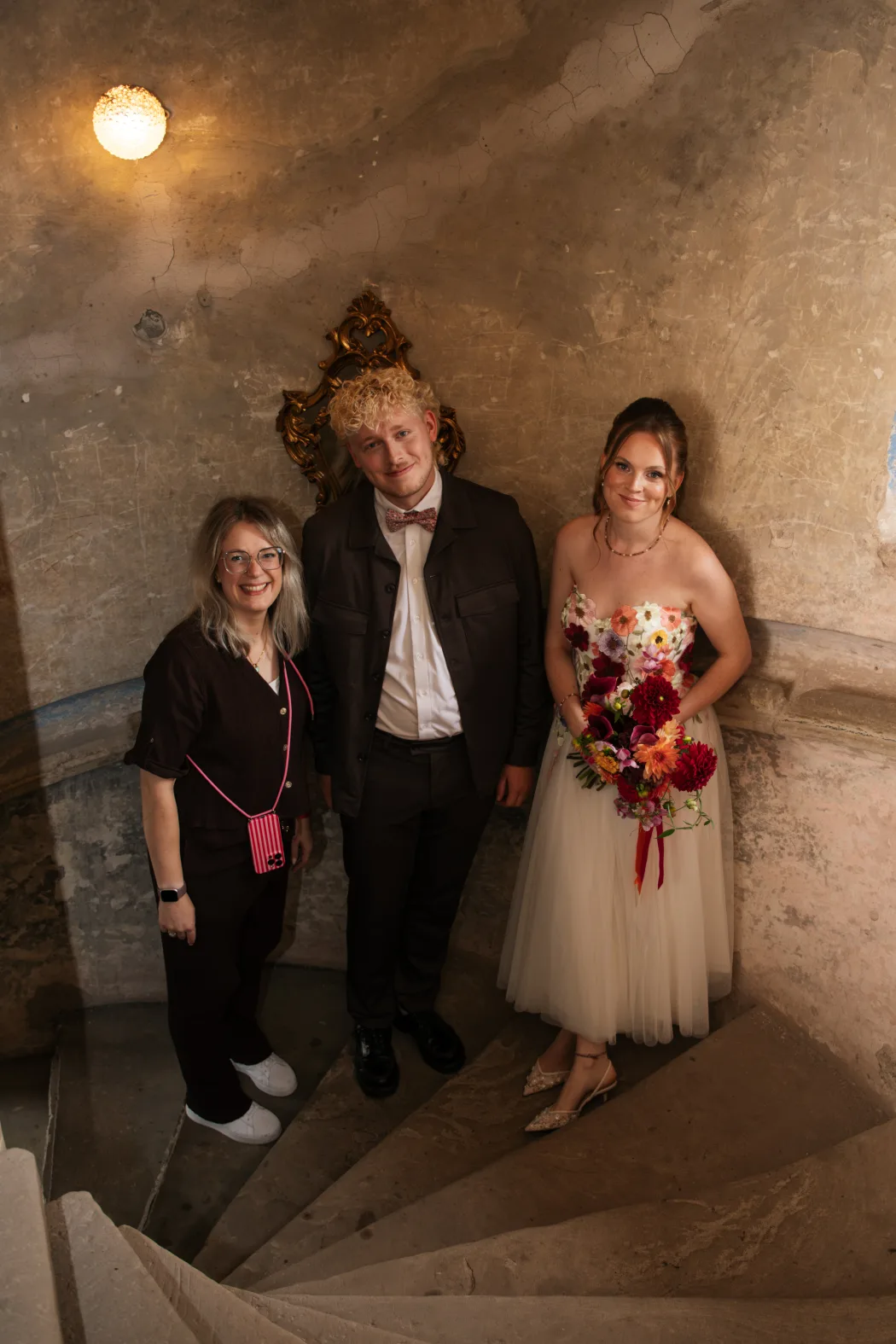 Yvonne Krienke mit dem Brautpaar im Treppenhaus von Schloss Weitersroda